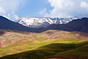 The countryside of Iran--flowing green hills and snow-capped mountains.